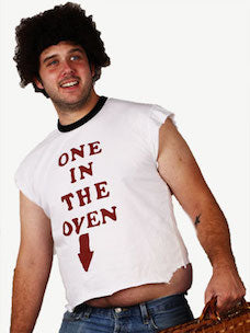 Costume Guide for Cadet Mahoney from the movie Police Academy.  Cadet Mahoney is wearing a curly wig, and a white t-shirt that says "One in the Oven" in red lettering, and jeans, and holding a wicker suitcase.