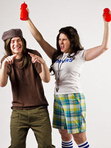 Costume guide for Slater and Darla from the movie Dazed and Confused.  Slater has long hair, wears a scally cap backwards, a brown t-shirt with a pot leaf on it, and olive green pants.  Darla wears a white t-shirt with blue lettering that says Seniors, plaid shorts, a whistle, and holds a red ketchup dispenser in each hand.