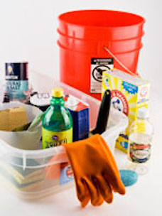 A plastic bin full of items you need to age your t-shirts: rubber gloves, salt, sponges, vinegar, baking soda, and a red bucket.