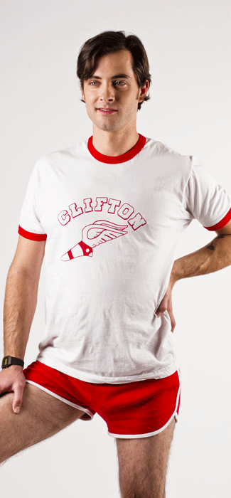 Costume guide for McKinley from the movie Wet Hot American Summer.  McKinley has dark brown hair and wears a white t-shirt with red bands around the neck and sleeves.  The shirt says "Clifton" in red lettering and shows a foot with wings. 