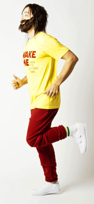Costume guide for Sam Bell from the movie Moon.  Sam has shaggy brown hair and a beard.  He wears a yellow t-shirt with red lettering on it that says "Wake Me When It's Quitting Time," and red sweatpants.