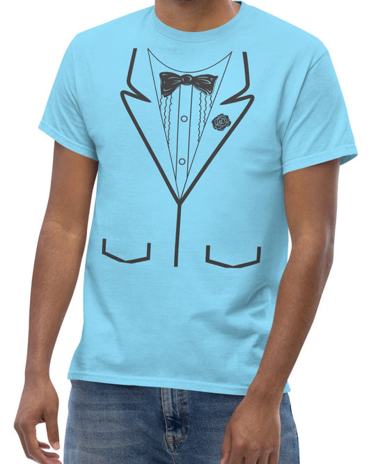 A man wearing a light blue t-shirt with a black line art graphic of a tuxedo jacket, shirt, bow tie, and pocket lines, paired with blue jeans against a plain white background.